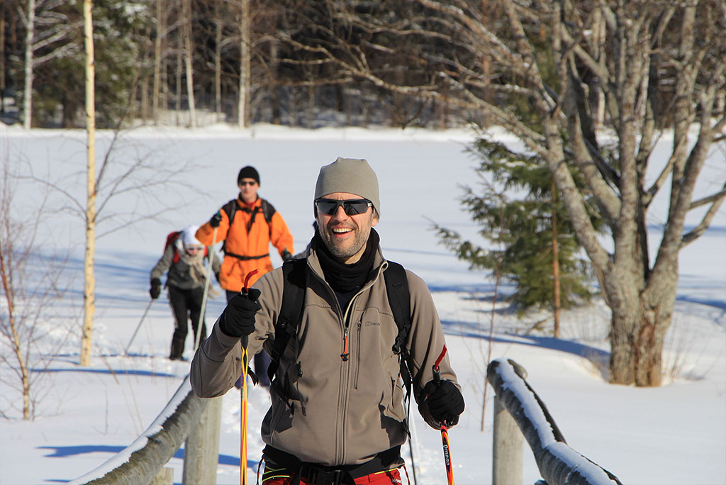 Eine Gruppe Menschen beim Skilanglauf durch eine verschneite Winterlandschaft